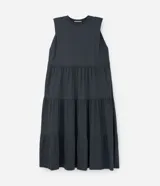 Vestido midi gris sin mangas, con cuello redondo, corte recto y volados en la falda.