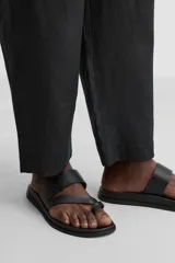 Sandalias de cuero negro con tiras anchas y plantilla anatómica.