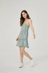 Vestido corto con estampado floral, breteles finos, corte holgado y cuello redondo.