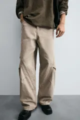 Pantalón de jean color beige, corte holgado y amplio en toda la pierna, tiro medio, tejido rígido, cinco bolsillos, efecto lavado y detalle de pinzas en perneras.