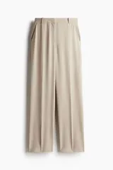 Pantalón de vestir color beige, de tiro alto, con cierre, botón oculto y corchete. Piernas rectas con pliegues adelante y atrás, bolsillos al bies y bolsillos insertados atrás.