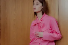 Camisa rosa de popelina de algodón con cuello con lazo y mangas largas.