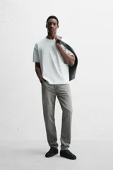 Pantalón de jean azul oscuro, corte slim fit, tiro medio, cinco bolsillos, tejido elástico y efecto lavado.