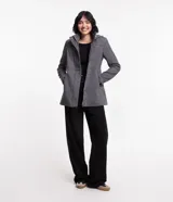 Saco largo de polivelour con textura espina de pez en tonos grises. Tiene cuello alto, capucha, cierre delantero con botón y cremallera, manga larga y bolsillos.