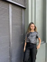 Top corto con estampado brillante en tonos plateados y negros, de manga corta.