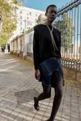 Minifalda azul petróleo de satén con encaje negro en el frente, corte al bies y cierre lateral invisible.