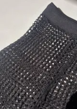 Pantalón de red negro de tiro alto y corte acampanado.