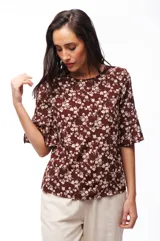 Blusa marrón con estampado floral blanco, de mangas cortas acampanadas y corte holgado.