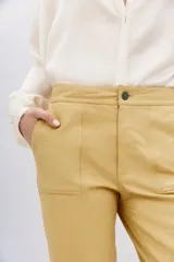 Pantalón de cuero ovino color dorado, de corte recto y largo al tobillo.