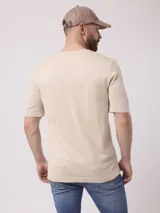 Remera de mangas cortas color beige, tejida en punto liso.