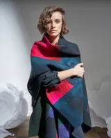 Ruana de 100% lana merino afieltrada, con diseño geométrico en colores inspirados en cultivos rurales.