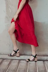 Sandalias de cuero charol negro con tira delantera y tobillera con hebilla metálica. Taco de madera con forma geométrica.