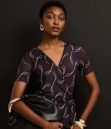 Mono largo de microfibra con estampado geométrico en tonos marrones y blancos. Tiene escote en V, mangas cortas y lazo ajustable en la cintura.