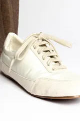 Zapatillas deportivas verde oliva con cordones y suela marrón.