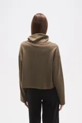 Buzo negro de manga larga con cuello alto tipo chimenea y un bolsillo cuadrado en el pecho.