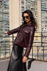 Campera corta de cuero ovino color borgoña, estilo jeanera, con cuello clásico, bolsillos con solapa y cierre frontal con broches metálicos.