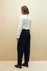 Pantalón negro de corte recto con bolsillos laterales y cintura elástica.