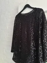 Minivestido negro con lentejuelas, de manga larga y escote redondo.