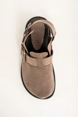 Zueco color visón de cuero con hebillas plateadas y suela negra.