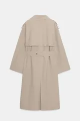 Gabardina larga color beige, con cuello solapa, manga larga con trabillas en hombros y cierre frontal cruzado con botones negros. Incluye cinturón a tono anudado.