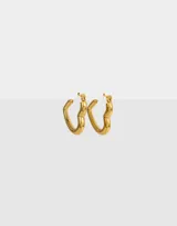 Aros tipo argolla con forma de corazón, hechos de acero quirúrgico color dorado.