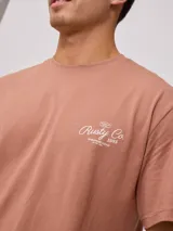 Remera color ladrillo de corte holgado, con estampa en la espalda con el logo de la marca y texto alusivo al surf.