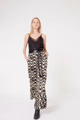 Pantalón palazzo con estampado de ondas en tonos blanco, negro y dorado.