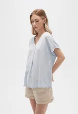 Blusa color beige de lino, holgada y con cuello en V.
