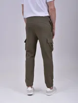 Pantalón de jogging color beige con bolsillos cargo laterales, cintura ajustable con cordón y puños elásticos.