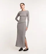 Pollera midi gris de rib acanalada con hilo metalizado, cintura elástica, abertura lateral y bajo ondulado.
