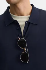 Polo de punto azul marino de corte regular fit, tejido en hilatura con mezcla de algodón y seda. Tiene cuello solapa con cierre frontal de botonadura, manga larga y acabados en rib.