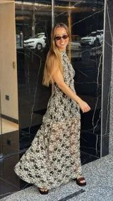 Vestido midi de encaje floral color beige sobre base negra, con cuello halter y falda con vuelo.