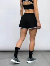 Short deportivo gris con ribetes celestes en ruedo y cintura.