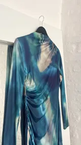 Vestido midi de cuello alto, color azul con estampado abstracto en tonos celeste, blanco y verde.