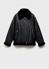 Chaqueta biker negra de efecto piel con cuello de borreguito, cierre de cremallera asimétrico, bolsillos laterales con cremallera y terminaciones de borreguito.