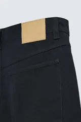 Pantalón de jean color crudo, corte amplio y tiro alto, con cinco bolsillos y cierre frontal con botones.