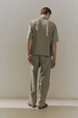 Camisa color beige de manga corta con cuello inglés y tapeta con botones. Corte holgado.