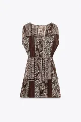 Vestido corto con estampado de cachemira en tonos marrones, beige y verde. Tiene escote en pico con abalorios, mangas cortas y cintura elástica con cinturón fino.