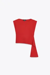 Top rojo de punto con cuello redondo y sin mangas. Diseño asimétrico con caída lateral.