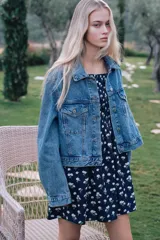 Vestido corto de popelina azul marino con estampado de pequeñas flores blancas, escote cuadrado con elástico fino sobre los hombros, mangas cortas abullonadas con fruncido elástico, cuerpo ajustado fruncido y falda con vuelo. Ribete de volado en escote y puños.