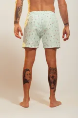 Bañador de hombre color rosa pálido con estampado de golondrinas oscuras. Presenta cintura elástica con cordón ajustable de color crudo y terminales turquesa.