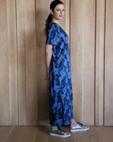 Vestido negro de corte recto, largo midi, con escote en V y mangas cortas.