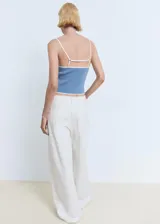 Top de punto fino color azul claro, ajustado al cuerpo, con tirantes finos y ribetes de contraste blancos en el escote y el ruedo.
