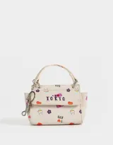 Monedero de cuerina color crudo con estampado de motivos japoneses y la palabra "Tokyo". Tiene forma de bolso con manija superior, solapa con broche a presión y mosquetón lateral.