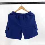 Bermuda azul marino de algodón fino con textura waffle, corte recto, cintura elástica con cordón ajustable, bolsillos laterales y bolsillos cargo con solapa en los laterales.