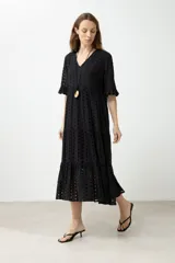 Maxi vestido negro con bordado tipo broderie, escote en V y mangas cortas con volados.