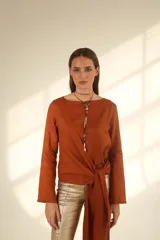 Blusa rosa de lino con corte asimétrico y lazo en la cintura.