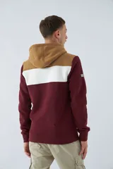 Buzo canguro de felpa gris oscuro con capucha ajustable, bolsillo canguro y logo estampado en el pecho. Tiene una banda horizontal gris claro en la parte superior del pecho y los hombros.