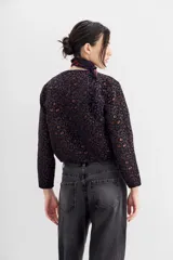 Campera bomber con estampado animal print, cuello redondo y corte a la cintura. Presenta detalle de cartera bordada en piedras y strass.