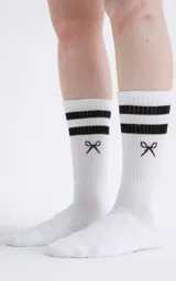 Medias blancas con dos rayas horizontales negras en la parte superior y un diseño de moño negro en el tobillo.